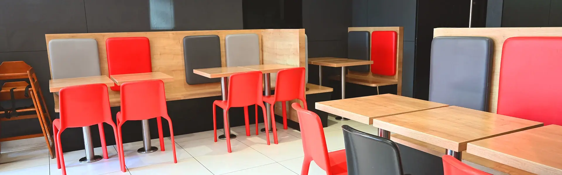 Salle du restaurant GUR Kebab Roubaix avec tables, banquettes et chaises rouges